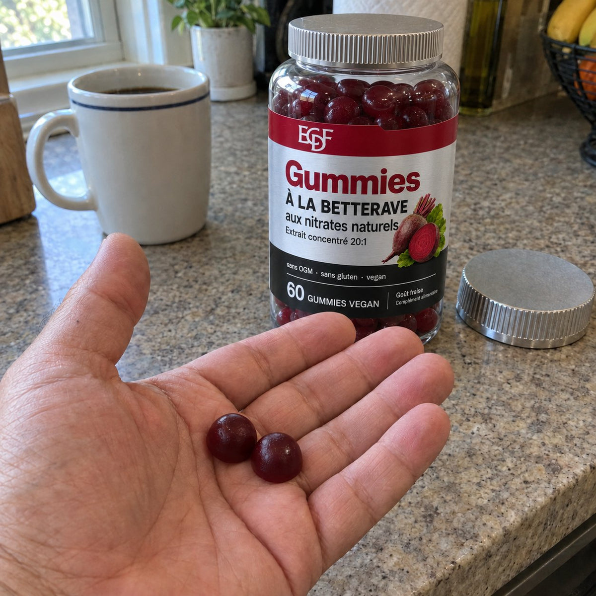 Deux gummies à la betterave dans la main, le pot derrière