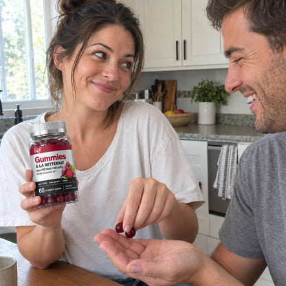 Elle lui tend deux gummies à la betterave dans la cuisine